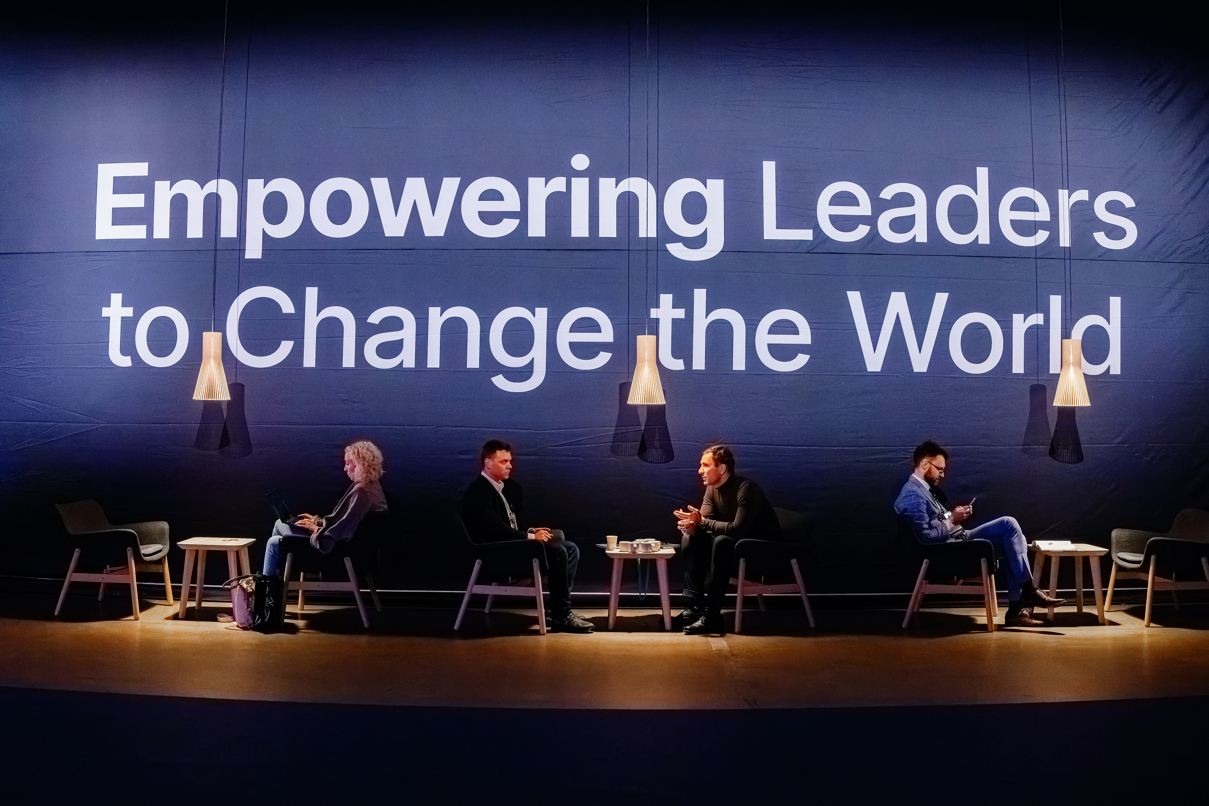 Nordic Business Forum main stage with a panel of speakers in front of a large ‘Empowering Leaders to Change the World’ backdrop