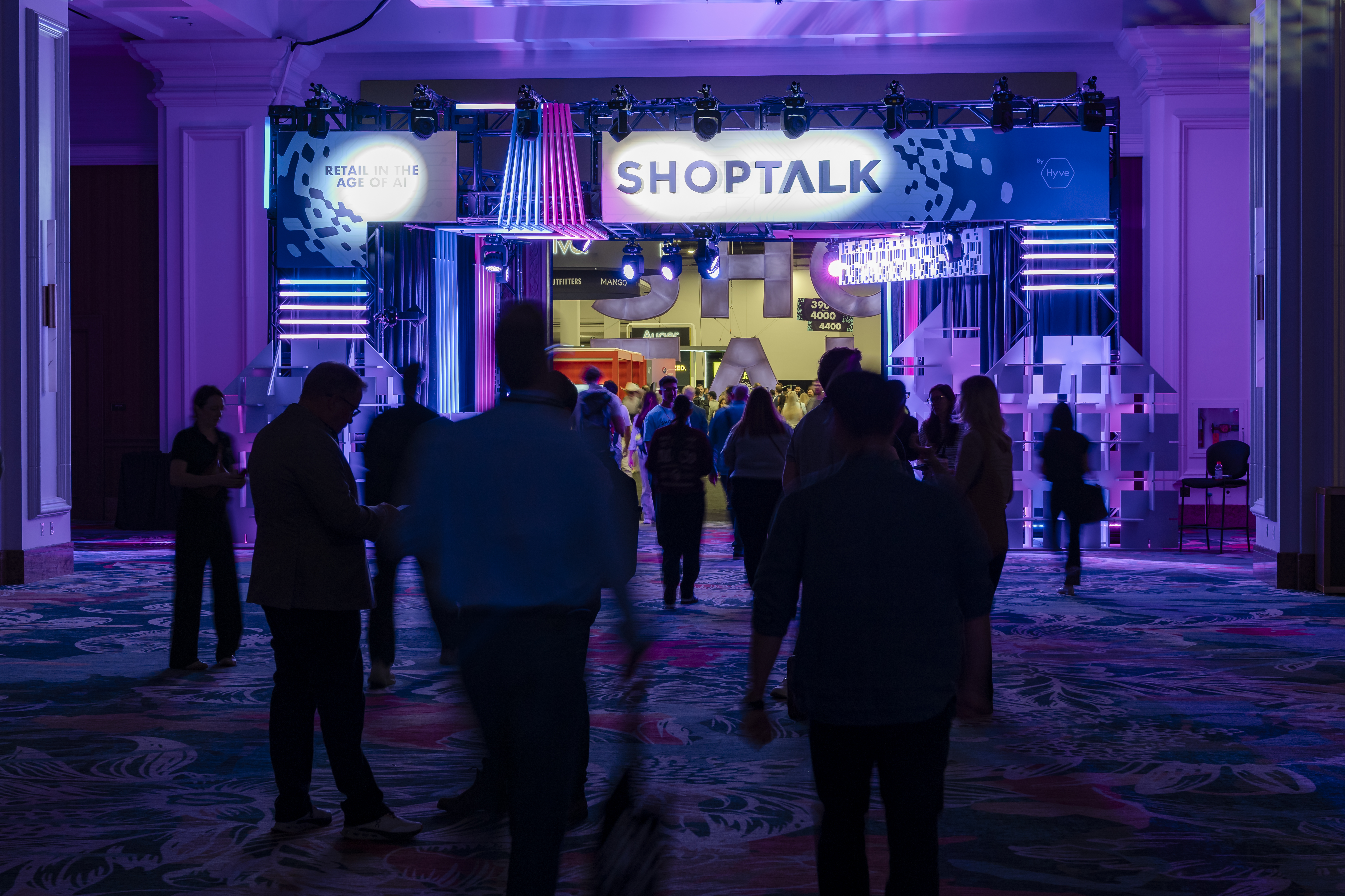 Entrance area at Shoptalk with illuminated ‘SHOPTALK’ signage and blue lighting as attendees arrive