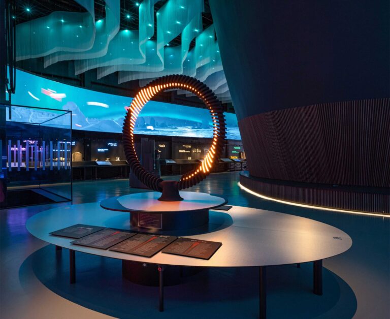 Illuminated ring sculpture on a plinth in front of a curved screen at Finland’s Expo 2020 Dubai pavilion