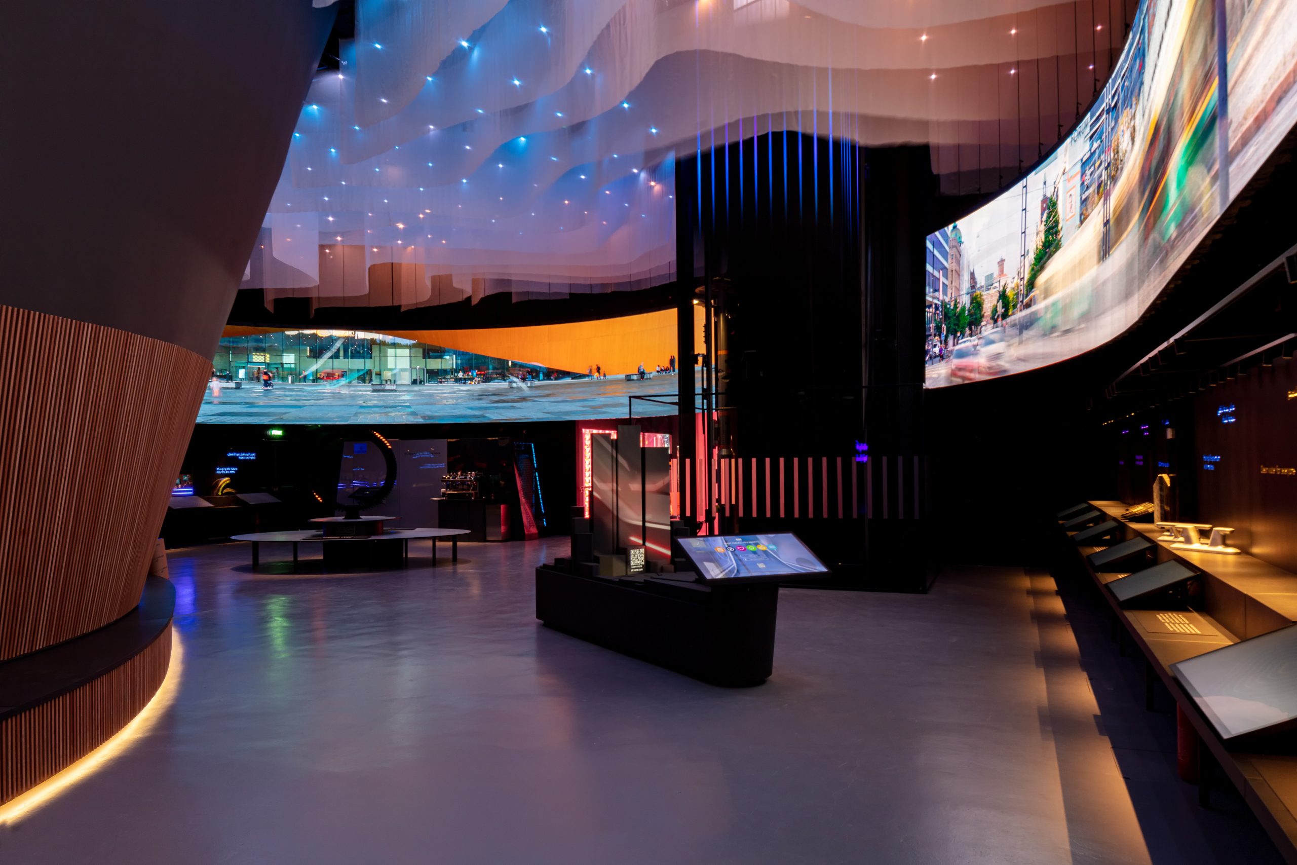 Interior of Finland’s Snow Cape pavilion at Expo 2020 Dubai, a curved hall with a draped white ceiling and wraparound video walls