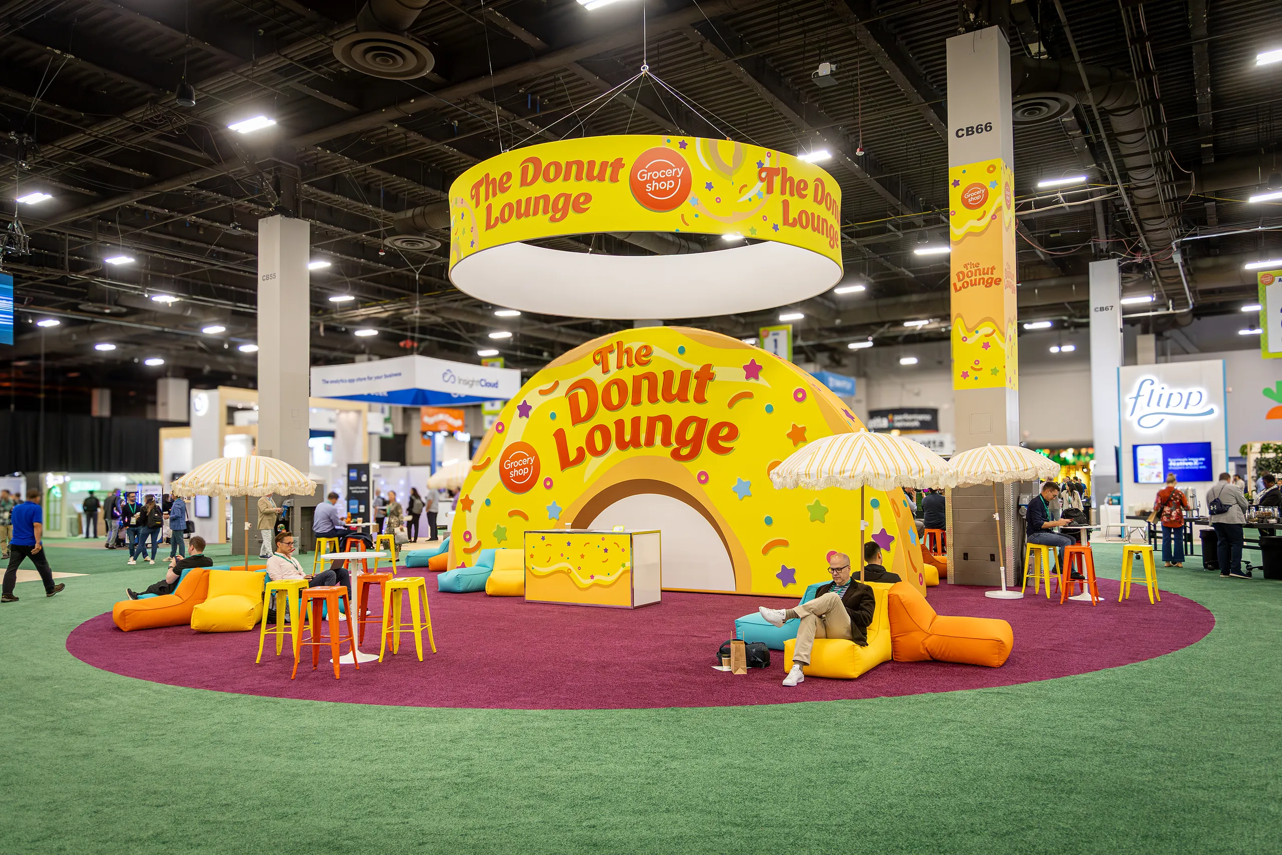 ‘The Donut Lounge’ at Groceryshop, a yellow donut-themed seating area with bean bags on a pink circular rug in the expo hall