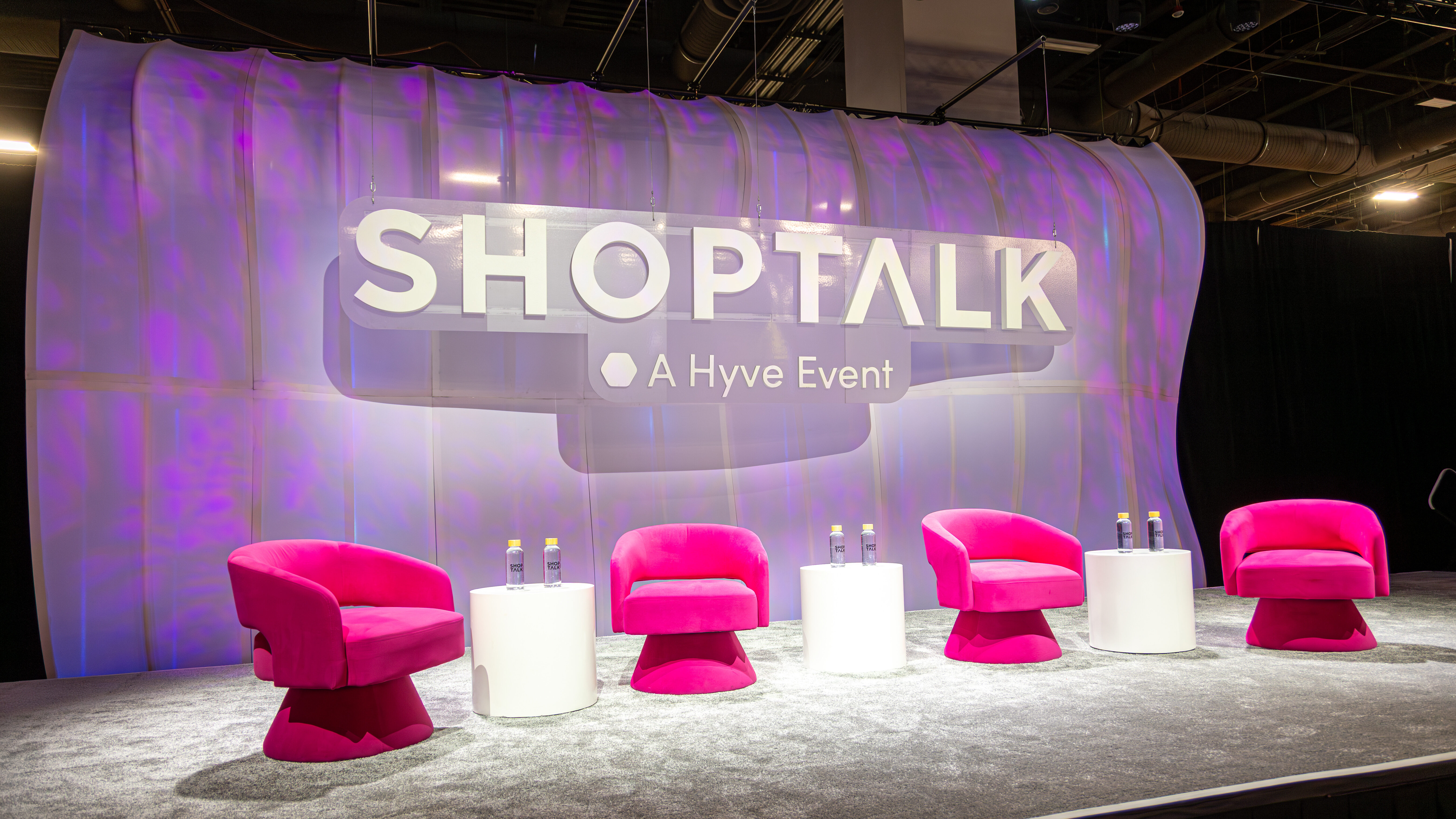 The finished Shoptalk stage: a purple textured curved backdrop reading ‘SHOPTALK’ with pink armchairs and white tables